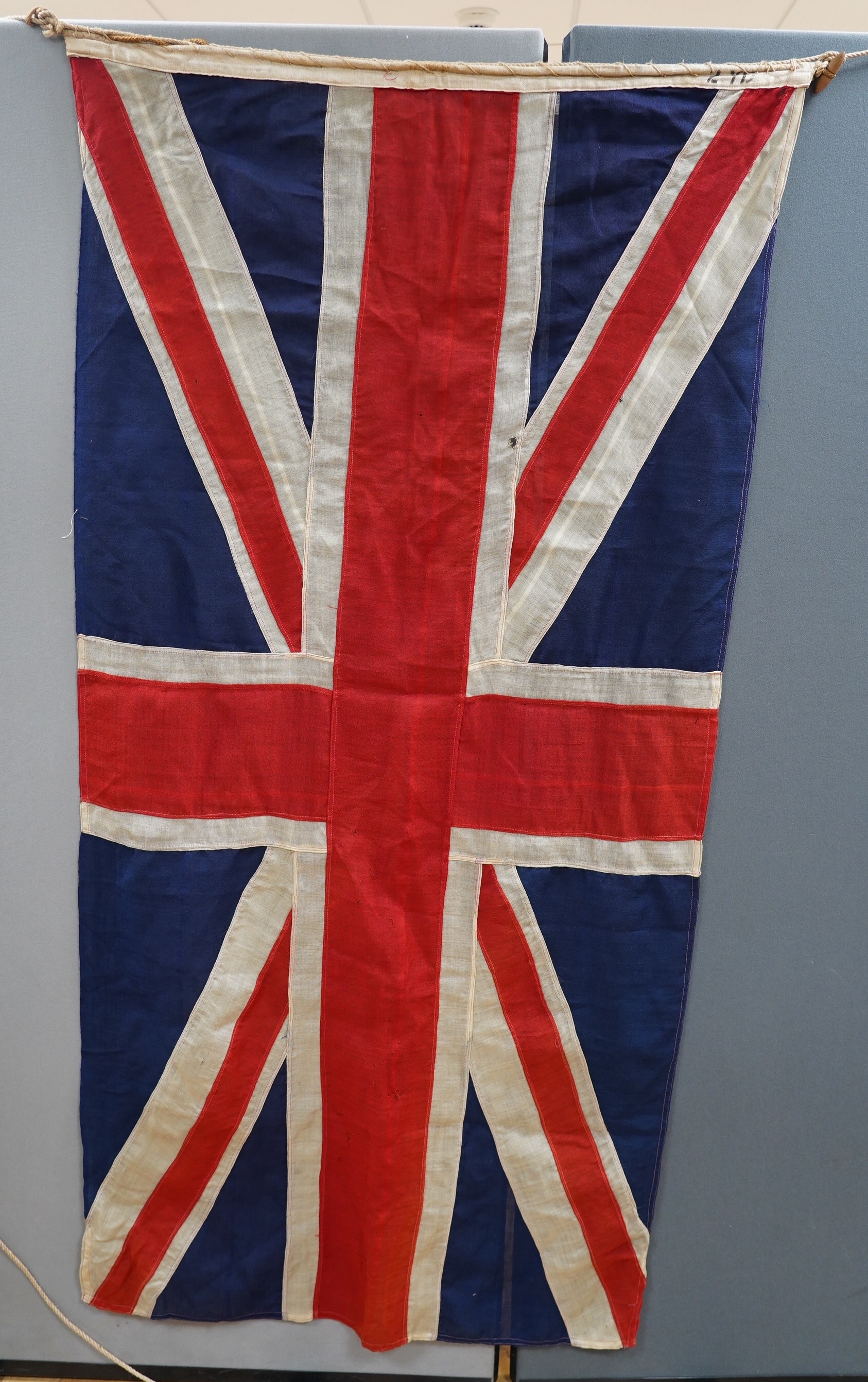 Eight mostly mid 20th century Union Jack flags, one celebrating Queen Victoria’s Diamond Jubilee, together with a Saint George’s cross and a string of Union flag bunting. Condition - poor to good